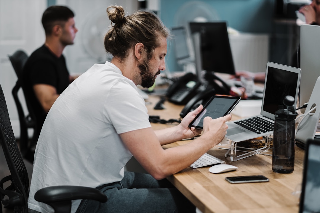A man seated at a desk, engaging with a tablet to improve customer personalization through AI innovations.